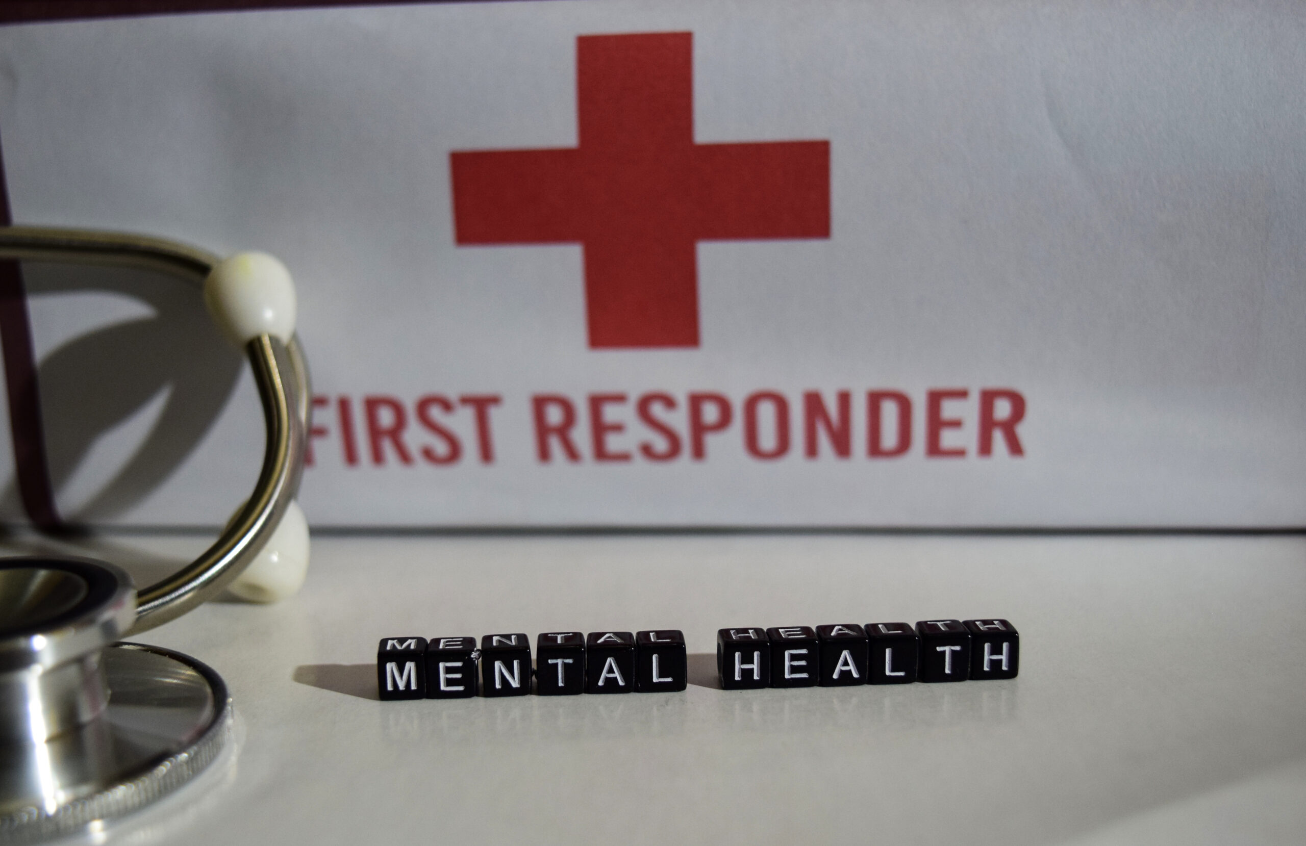 First responder sign nestled among colorful mental health awareness blocks, highlighting the critical connection between emergency services and mental fatigue management.