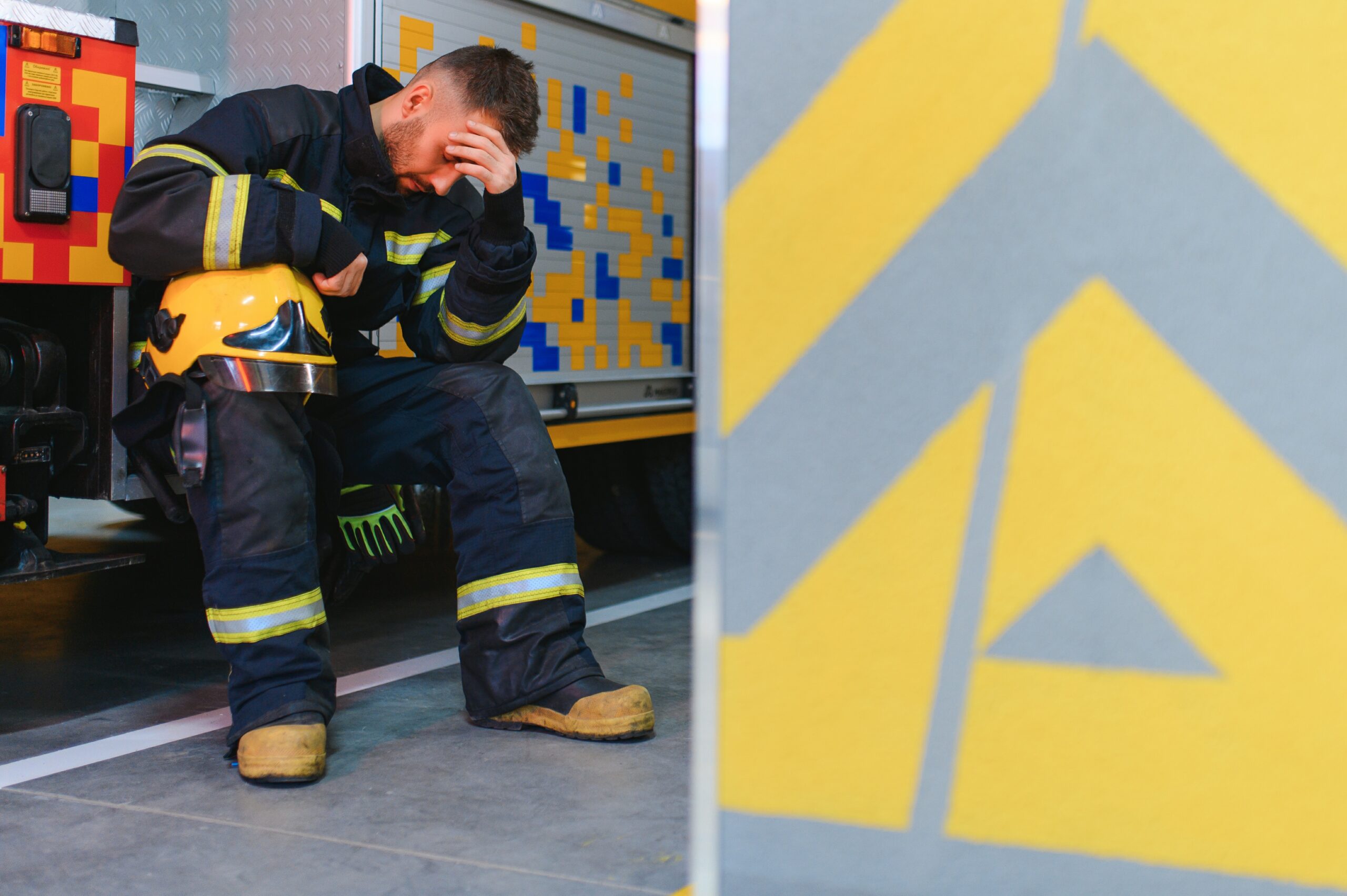 A firefighter, in full gear, bows his head in a moment of emotional exhaustion and depression, highlighting the mental health challenges faced by first responders. A firefighter, in full gear, bows his head in a moment of emotional exhaustion and depression, highlighting the mental health challenges faced by first responders.