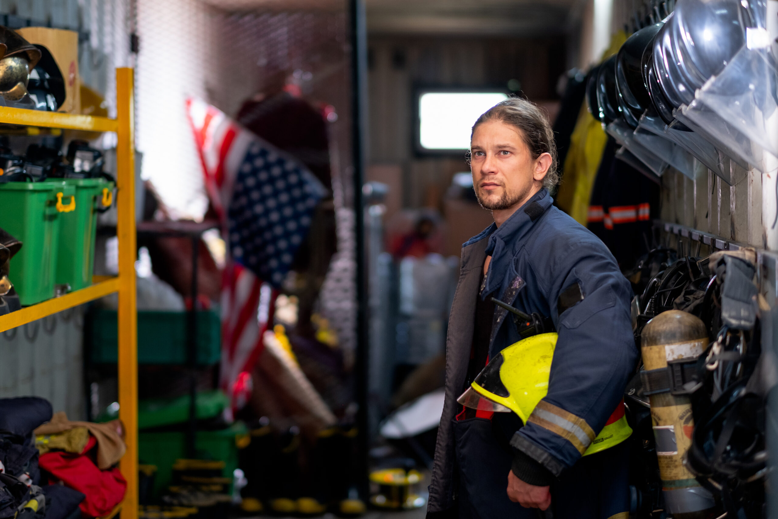 Firefighter first responder gearing up at the firehouse, ready to respond to a call, exemplifying sensory modulation in preparation for the intense scenario ahead.