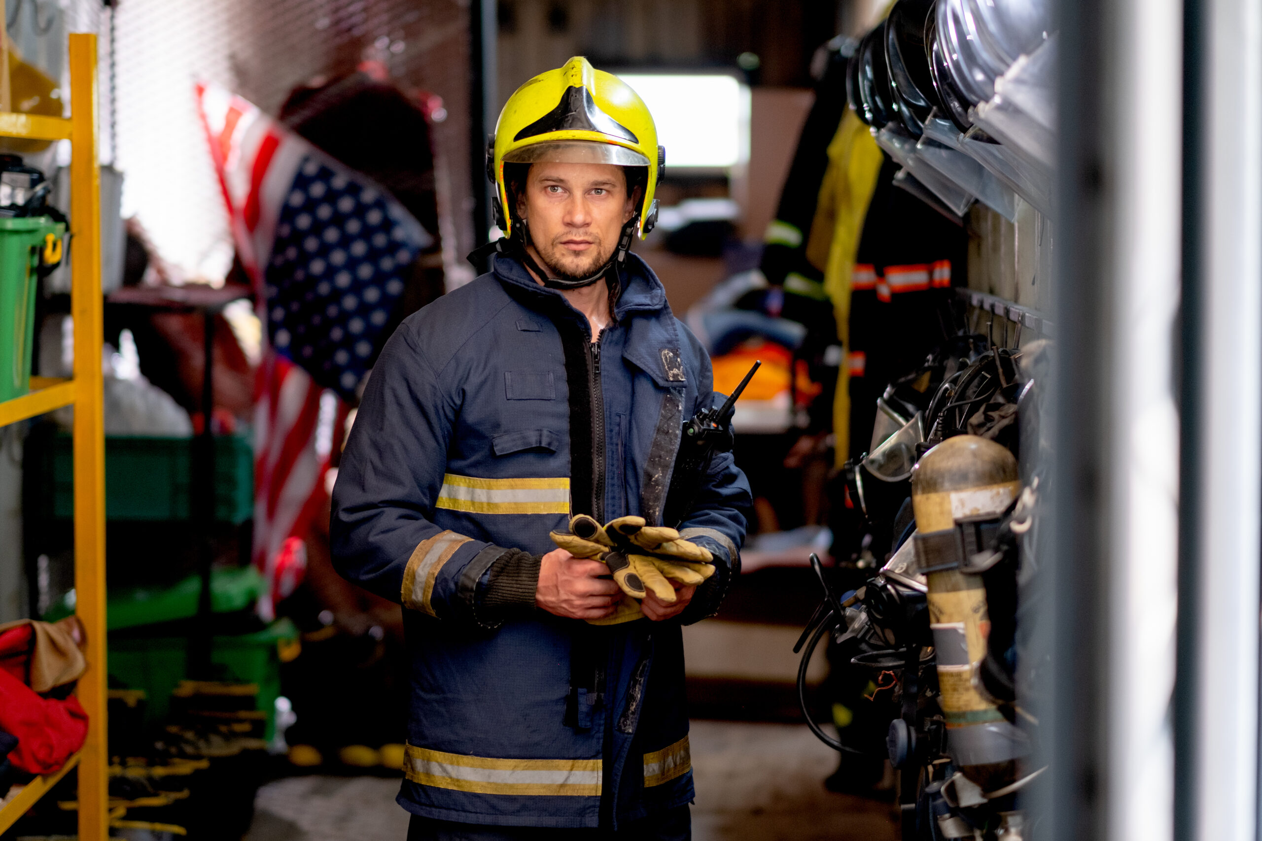 A firefighter methodically dons his gear, preparing to respond to an emergency, symbolizing the readiness to address mental health stigma in first responders.