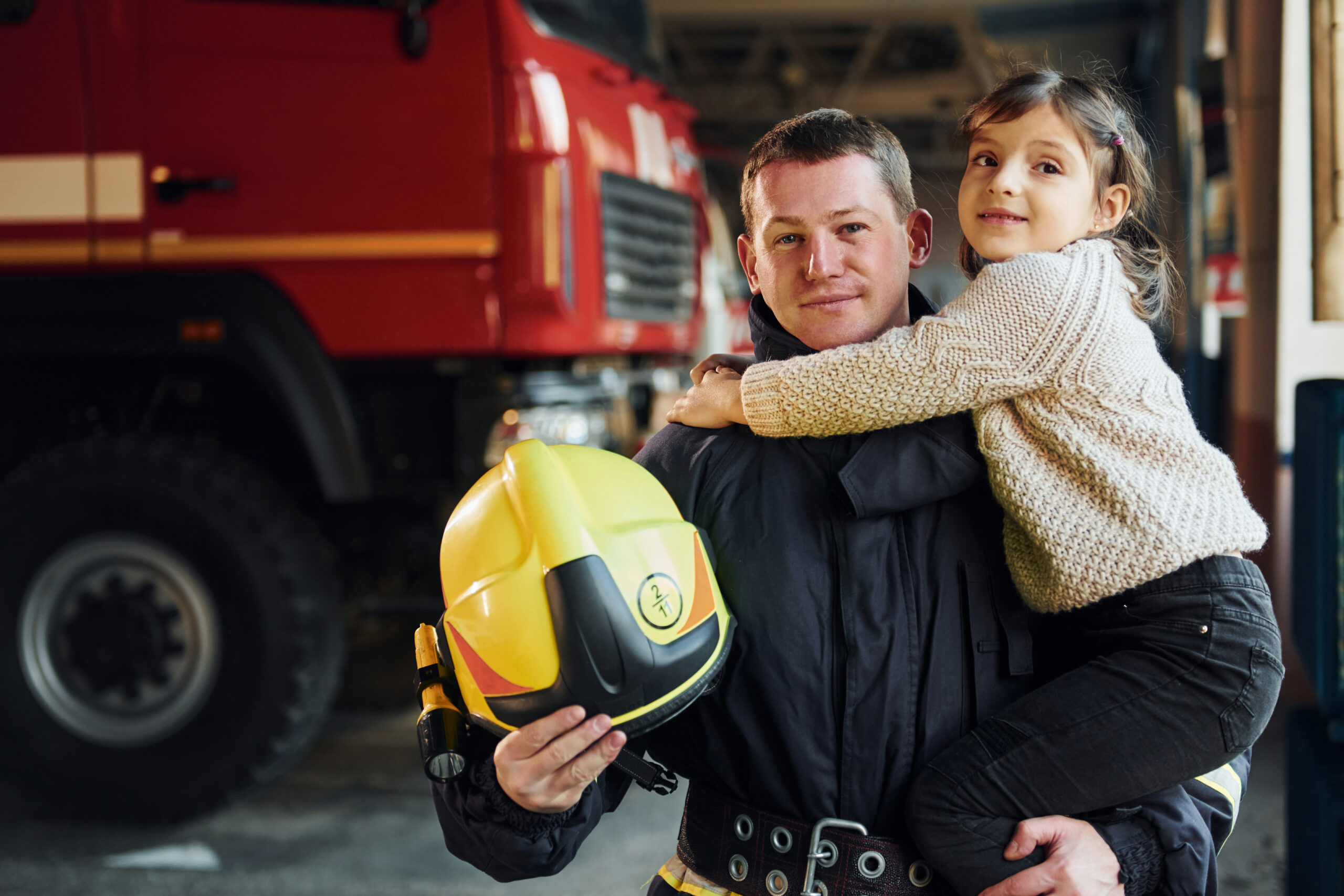 A concerned family sitting together on a couch, with a first responder in uniform looking distressed and holding their head in their hands. The family's faces show a mix of concern, empathy, and support, highlighting the impact of trauma on first responder families and the importance of family support.