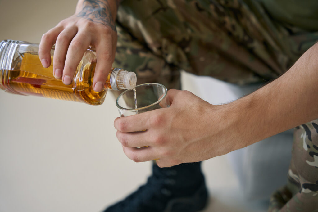 military person pouring himself glass of whisky 2023 11 27 05 24 37 utc After Action an AM Health Care Program