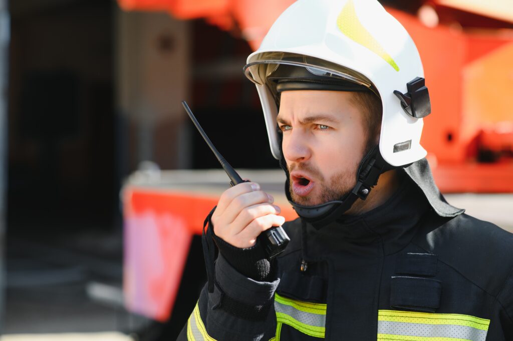 A first responder yelling into a walkie-talkie, illustrating the behavioral signs of mental health issues faced by first responders.