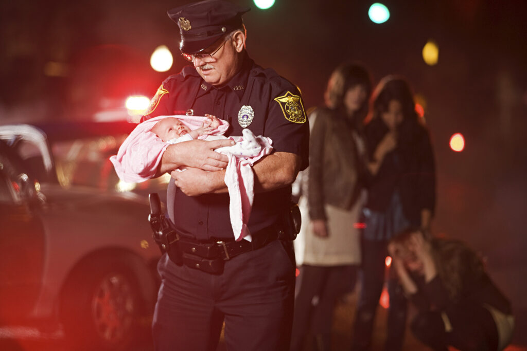 police officer cradling a newborn amidst an emerge 2024 06 05 18 30 46 utc After Action an AM Health Care Program